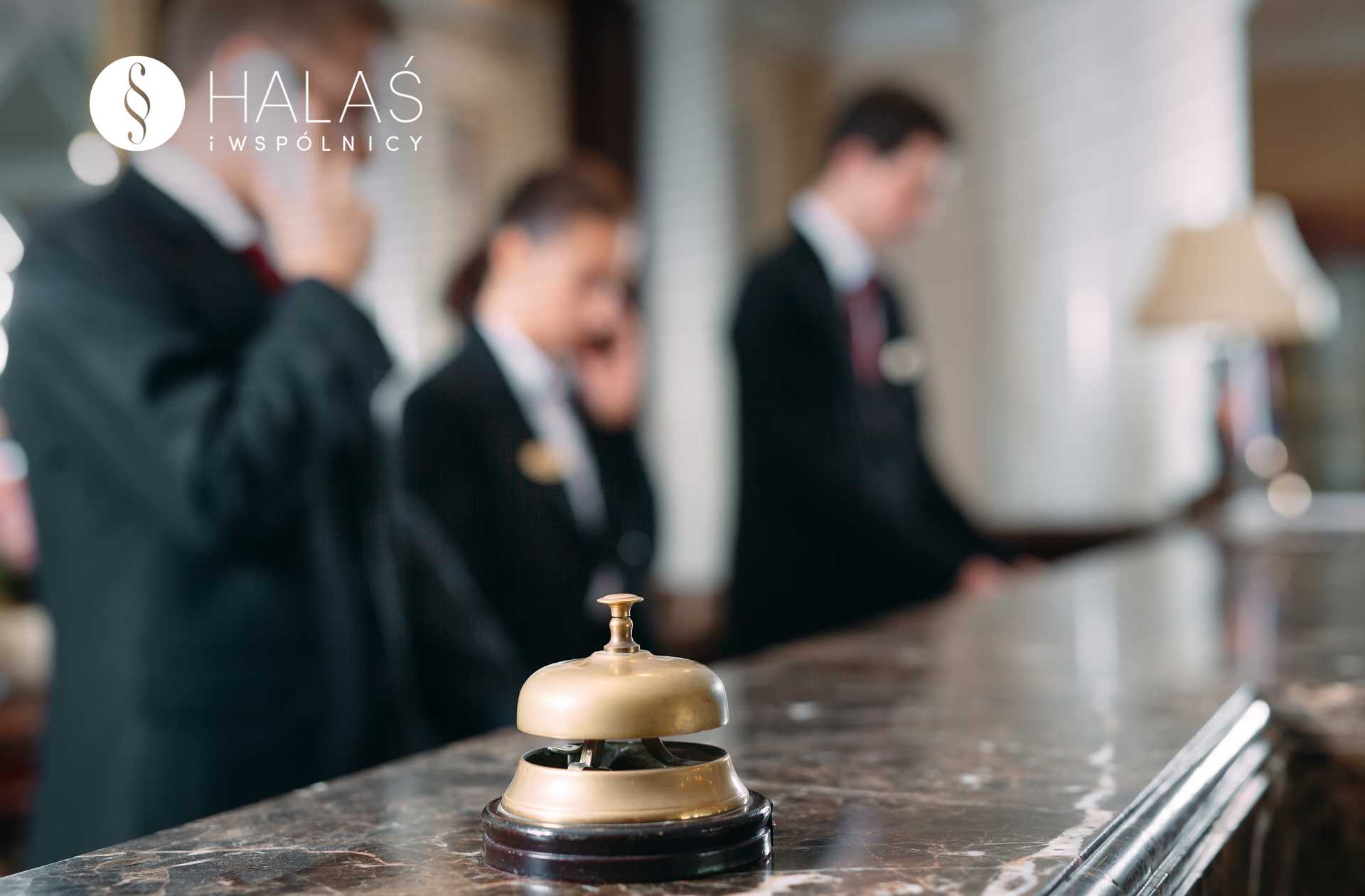 reklamacja-po-urlopie-dokumenty-wyrozniajacy Dzwonek na recepcji hotelu, w tle pracownicy obsługi – reklamacja usług hotelowych po urlopie