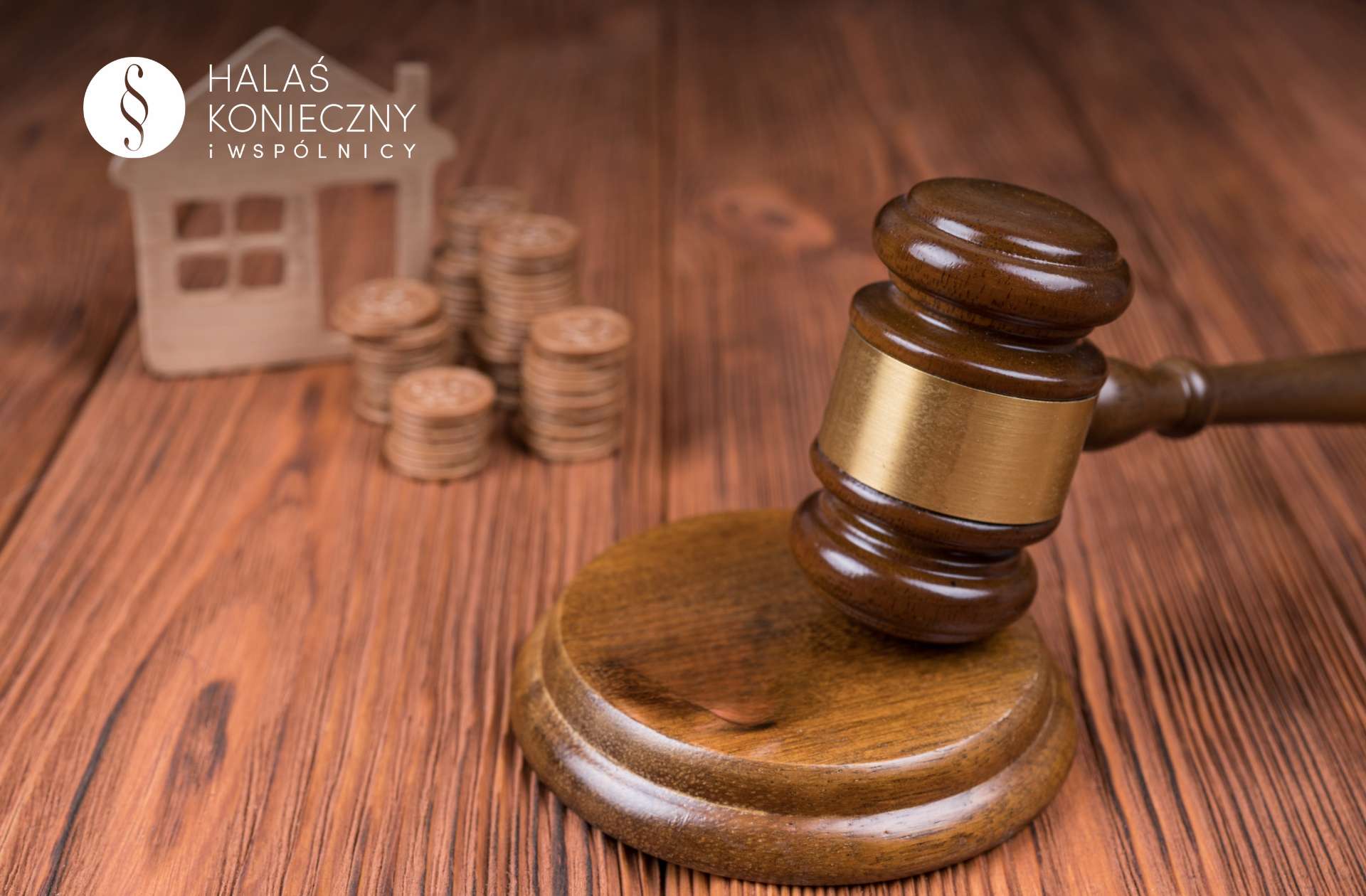 Figurka domku i pieniądze, przed nimi młotek sędziowski